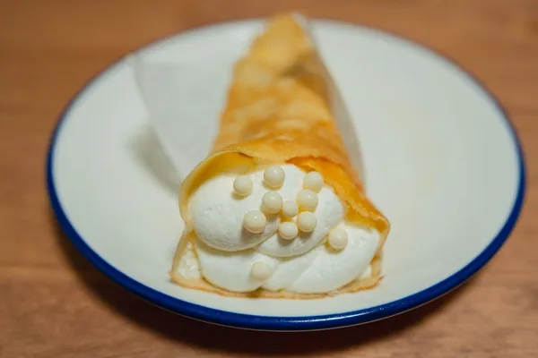 Crepe francês fino e dourado sendo virado na frigideira quente